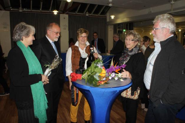 Blumen und Bier: Bargteheides Bürgervorsteherin Cornelia Harmuth (Mitte) neben Kandidat Manfred Kutsche und weiteren Gästen im Bürgerhaus-Saal.  