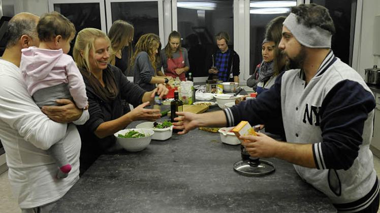Mitglieder vom Dabeler Helferkreis und Sternberger Gymnasiasten haben gemeinsam mit Flüchtlingen gekocht und danach in großer Runde gegessen.  