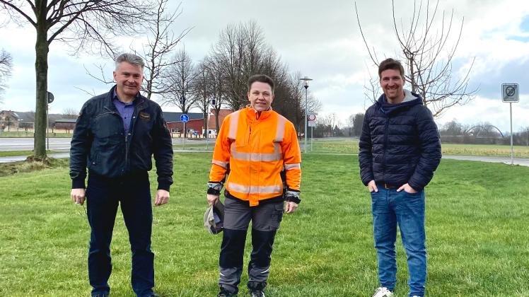 Zwischen den jungen Bäumen wird der Blühstreifen an der Zufahrt zur Apfelgarten-Siedlung angelegt. Ortsbürgermeister Wolfgang Kirstein-Bloem, Petra Hohlt (Bauhof) und Ortsbürgermeister Thomas Uhlen freut das.