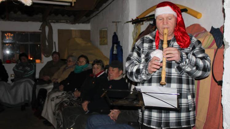 Torsten Grüneberg gibt ein kleines Flötenkonzert zum Besten. Auch in der Garage sitzen etliche Leute. Fotos: Traudel Leske 