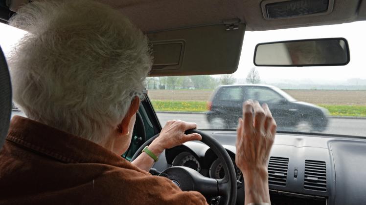 Eine alte Frau am Steuer ihres Kleinwagens.