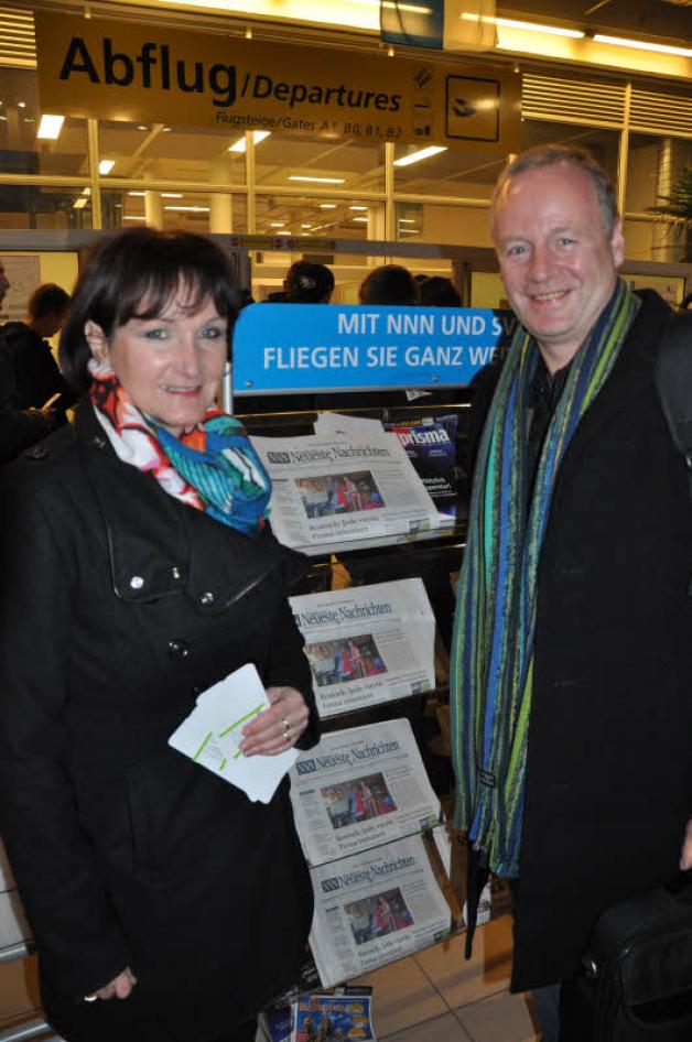 Heiko und Kathrin Steben, Gewinner der gemeinsamen Aktion von NNN und Lübzer, stehen auf dem Airport Laage vor dem Zeitungsstand mit sich selbst auf der Titelseite.