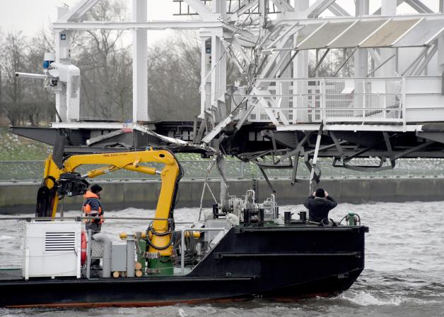 Mitarbeiter der Wasser- und Schifffahrtsverwaltung des Bundes (WSV) begutachten nach der Kollision der Rendsburger Schwebefähre mit einem Frachter vom Motorschiff „Sehestedt“ der Schifffahrtspolizei die Schäden an der Schwebefähre. 