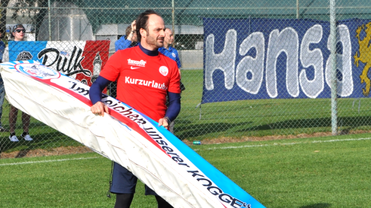 Hansa-Trainer Christian Brand war sich nicht zu schade, beim Aufstellen der extra aus Rostock mitgeführten Werbebanden mit Hand anzulegen.   