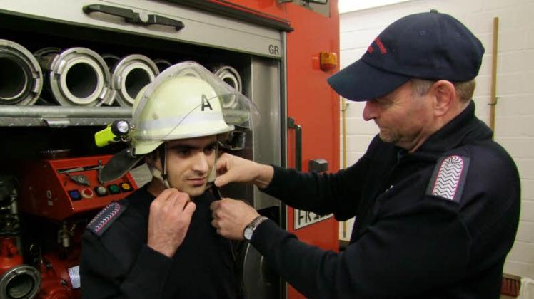 Helmprobe: Zaid Nayebi und Wehrführer Stefan Lorenzen testen die Ausrüstung für den frisch gebackenen Feuerwehranwärter. 