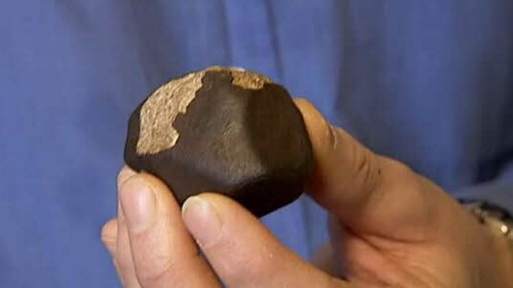 Eine schwerer magnetischer Stein  mit dunkler Schmelzkruste – Henning Haack vom dänischen Naturhistorischen Museum zeigt einen früher in Skandinavien gefundenen Meteoriten.   