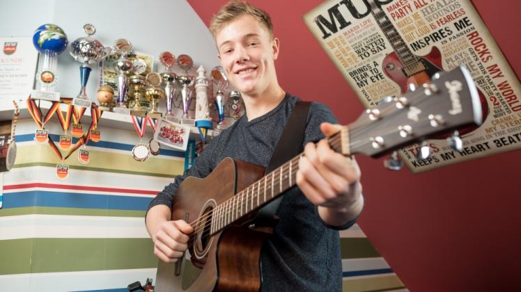 Er steht am Anfang seiner Shorttrack-Laufbahn, hat aber schon einiges an Erfolgen vorzuweisen: Moritz Kreuseler daheim in Sildemow vor seinen sportlichen Trophäen. Und mit Gitarre: „Ich spiele seit der 1. Klasse, aber nicht nach Noten, sondern mehr frei Schnauze“, sagt der 17-Jährige über sein Hobby.  