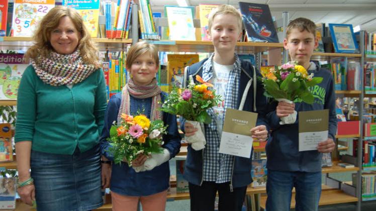 Angelika Rust (von links), Leiterin der Kinder- und Jugendbücherei, freute sich mit den drei Siegern Ann-Sophie Meier, Tim Reimers und Alex Bernhardt, die stolz ihre Urkunden und Blumen zeigten.  
