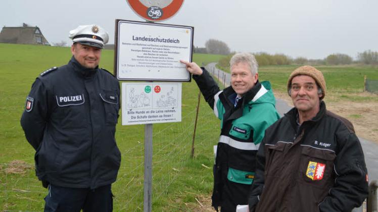 Weisen auf das Hinweisschild zur ganzjährigen Anleinpflicht hin: (v.l.) Michael Gohr, Thomas Langmaack und Bernd Kröger. 