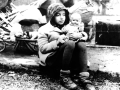 Ein Mädchen aus einem Flüchtlingstreck mit ihrer Puppe im Arm in den Wirren der Nachkriegszeit  