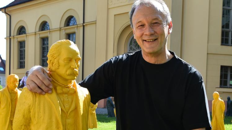 Der Künstler Ottmar Hörl steht mit einer Fontane-Figur vor der Kulturkirche.  