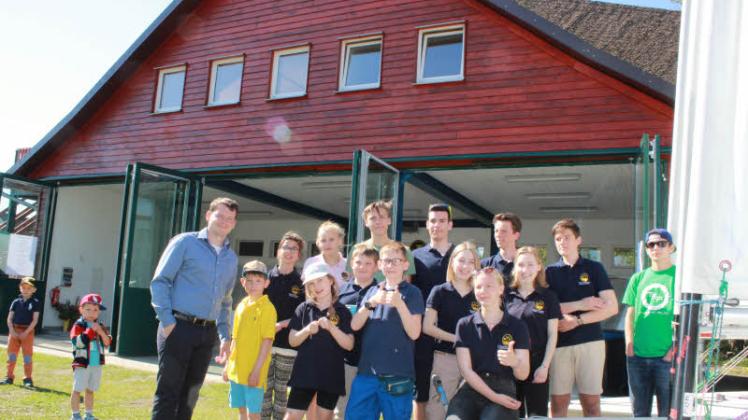 Die Kinder und Jugendlichen mit Jugendobmann Ludger Wetzke (l.) freuen sich über das neue Jugendhaus auf dem WVG-Gelände am Güstrower Inselsee.  