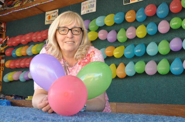 Zum Pfeilwerfen auf Luftballons lädt Marion Taube an ihrer Bude ein. Ihre meisten Besucher sind Kinder, sagt sie.  