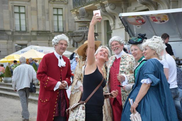 Moderne trifft Barock - eine Besucherin schießt ein Selfie mit den hochherrschaftlich gekleideten Gästen beim Schlossfest. 