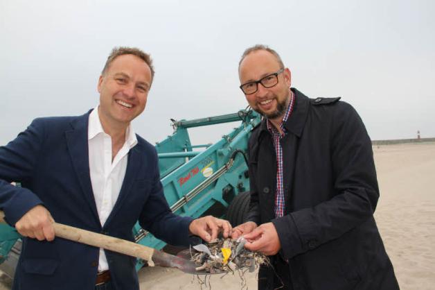 Was die Maschine aus dem Sand filtert, zeigen Umweltsenator Holger Matthäus und Tourismusdirektor Matthias Fromm: Steine, Kronkorken, Müll, Kippen und Plastik. 
