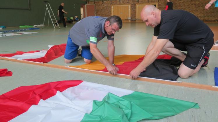 Jede Menge Kleinarbeit: Hier „basteln“ Burkhard Protz (r.) und Mario Bennühr an der Befestigung für die hochzuziehenden Flaggen der sechs teilnehmenden Nationen. 