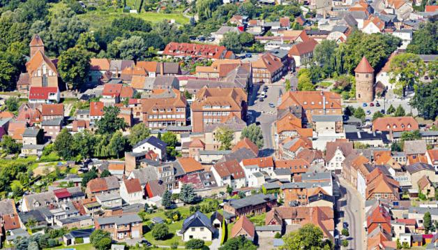 Blick auf Lübz: Die abseits des Marktes gelegene Stadtkirche ist von oben gut sichtbar, ebenso der Amtsturm (rechts im Bild).