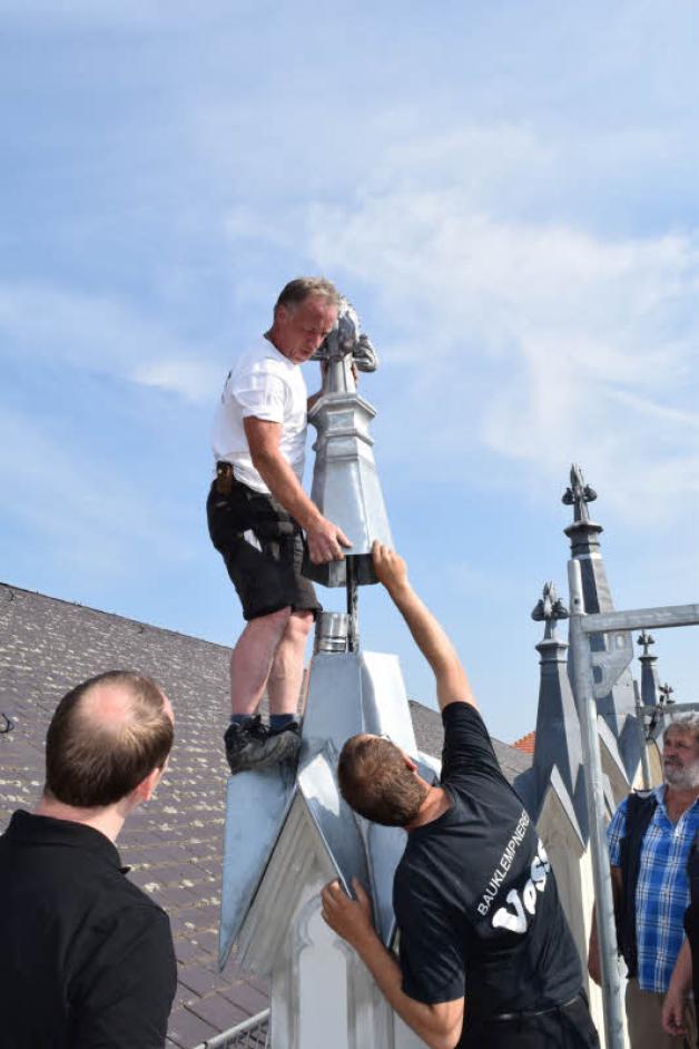 Wilfried Vossler (l.) hebt den 20 Kilogramm schweren Deckel auf den Turm. Wilfried Vossler (l.) hebt den 20 Kilogramm schweren Deckel auf den Turm.