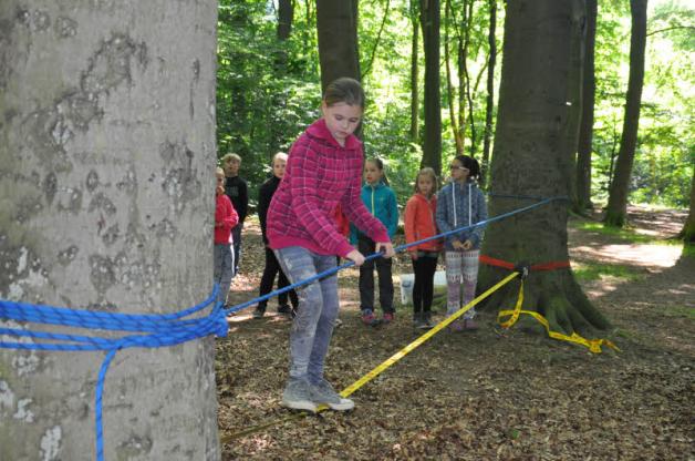 Erst das Seil gemeinsam spannen und dann darauf balancieren: Die zehnjährige Freya von der Gehlsdorfer Grundschule auf dem Weg zum Ziel.