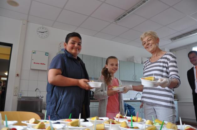 Mit viel Spaß dabei: In der Frühstückspause verteilt Renate Dunkelmann die Obstteller an Mariella Schröder und Mustafa Elias Westphal (v.l.) und die anderen Schüler.