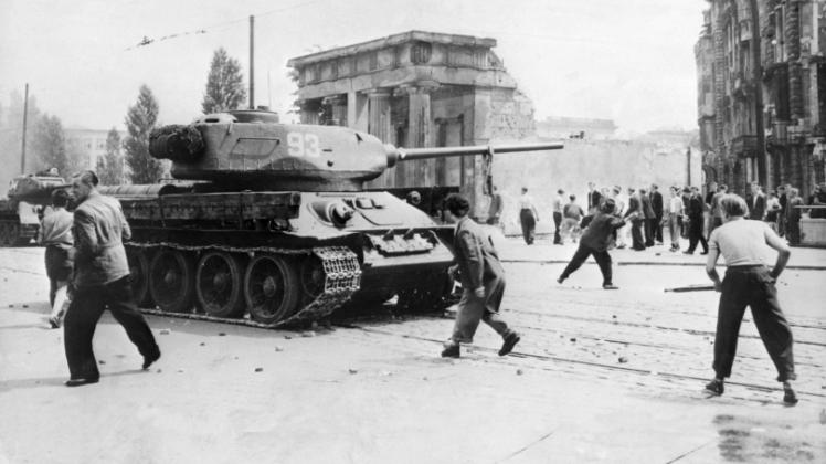 Demonstranten werfen am 17. Juni 1953 in Berlin mit Steinen nach sowjetischen Panzern.  