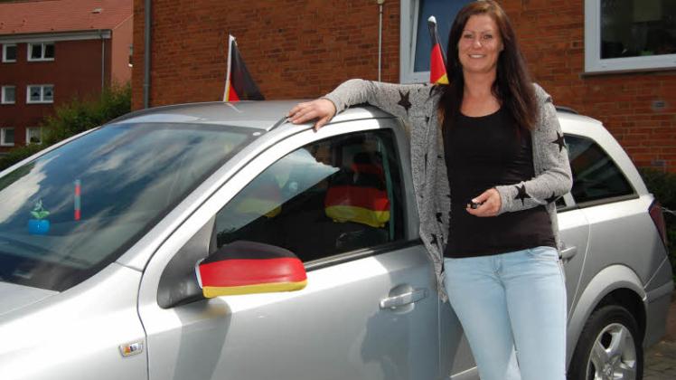 Zeigt zur EM Flagge: Vanessa Neumahr vor ihrem mit Schwarz-Rot-Gold geschmückten Opel Astra. 
