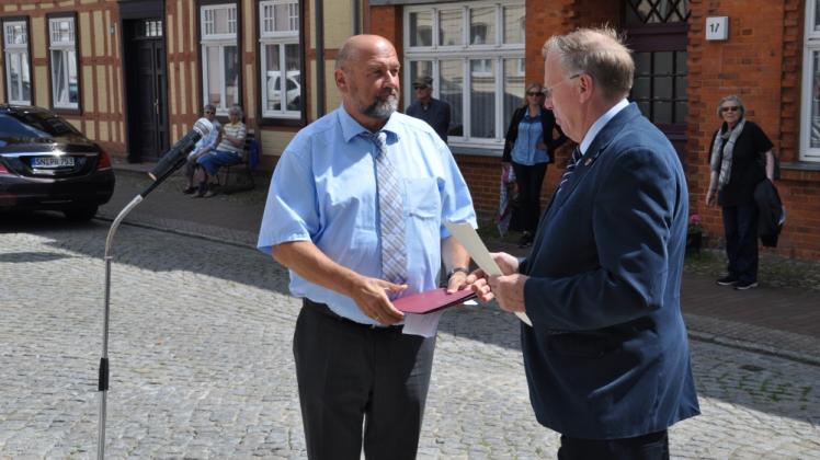 Wirtschaftsminister Harry Glawe überreicht Plaus Bürgermeister Norbert Reier die beiden Fördermittelbescheide. 