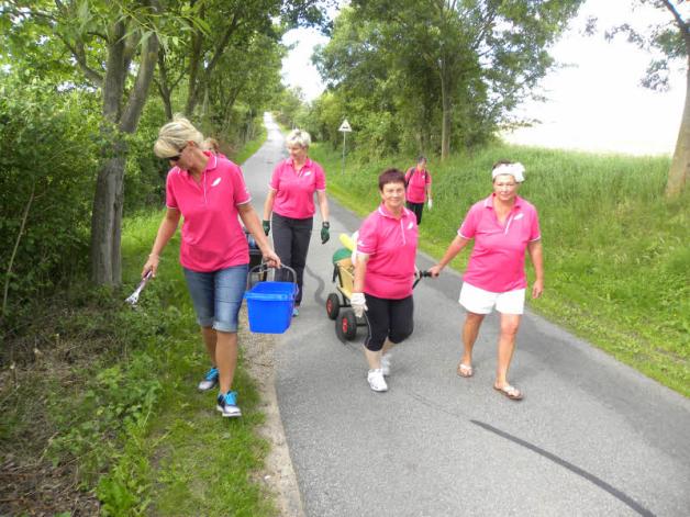 Die Frauen sammeln Müll entlang der Straße ein. Die Frauen sammeln Müll entlang der Straße ein.
