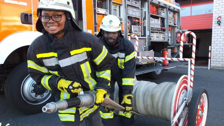 Mit Elan dabei: Carine Stephanie Tcholita (26) und Mohamed Nseli (29) trainieren das Abrollen des Schlauchs von einer sogenannten Haspel. Die Asylbewerber aus Kamerun wollen Mitglied der Fürstenwalder Feuerwehr werden.  