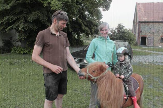 Dirk und Petra Saggau mit Tochter Liesbeth, die es sich auf Ponny „Coco“ bequem gemacht hat.