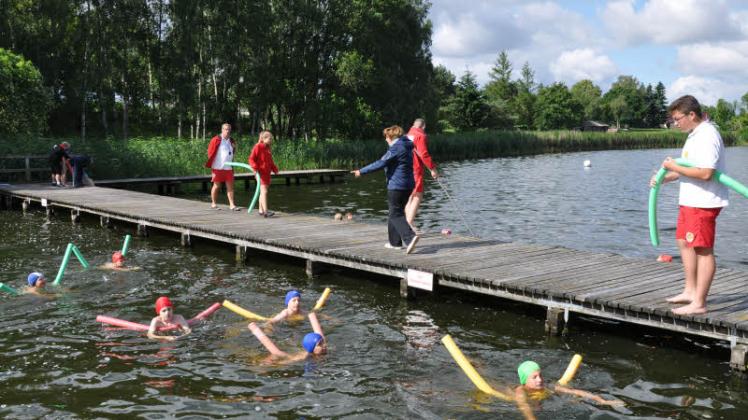 Langsam und die Arme weit ausbreiten: Die Schwimmlehrer geben den Schülern Tipps, wie sie mit ihren Schwimm-Nudeln am besten vorwärts kommen. Fotos: Heidrun Pätzold (3) 
