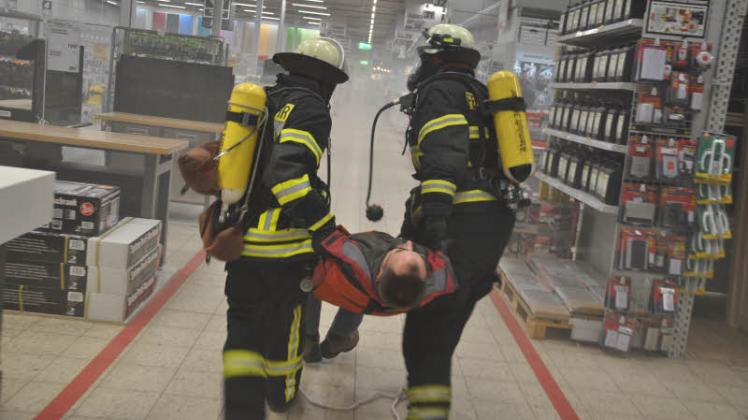 Einsatzkräfte der Feuerwehr bei einer Brandschutzübung in einem Ludwigsluster Baumarkt.  