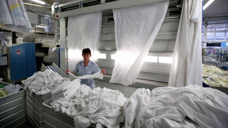 Andrea Regenberg kontrolliert im Wäschereibetrieb Targatz Handtücher. Die Trocknung läuft vollautomatisch. Doch auf Handarbeit kann das Unternehmen nicht verzichten.  