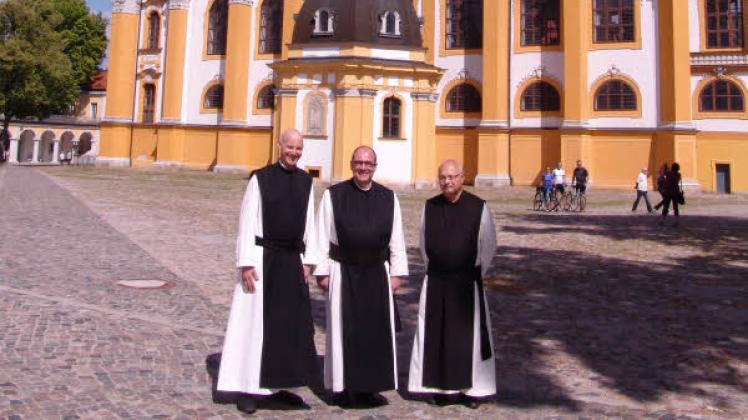 Drei der Mönche aus dem österreichischen Zisterzienserkloster Heiligenkreuz vor der Stiftskirche Neuzelle.  