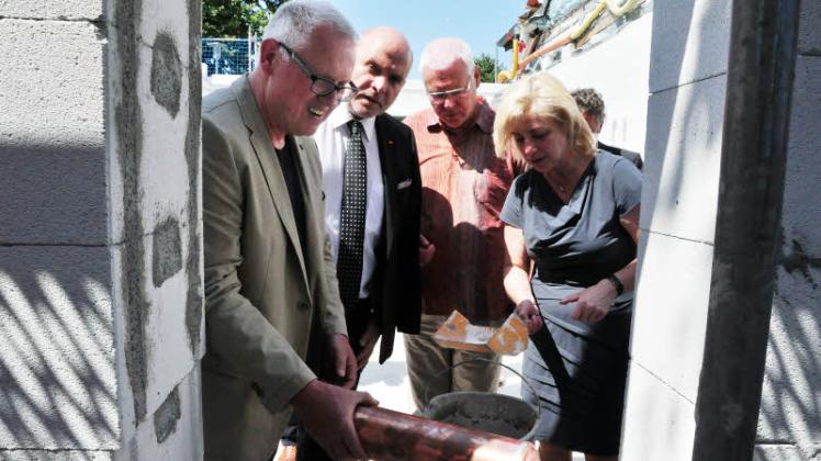 Gut gefüllt verstauten Bürgermeister Holger Bannuscher, Bundestagsabgeordneter Dietrich Monstadt, Alt-Bürgermeister Günter Lemke und Landrätin Kerstin Weiss (v.l.) die Kartusche in der Wand. 