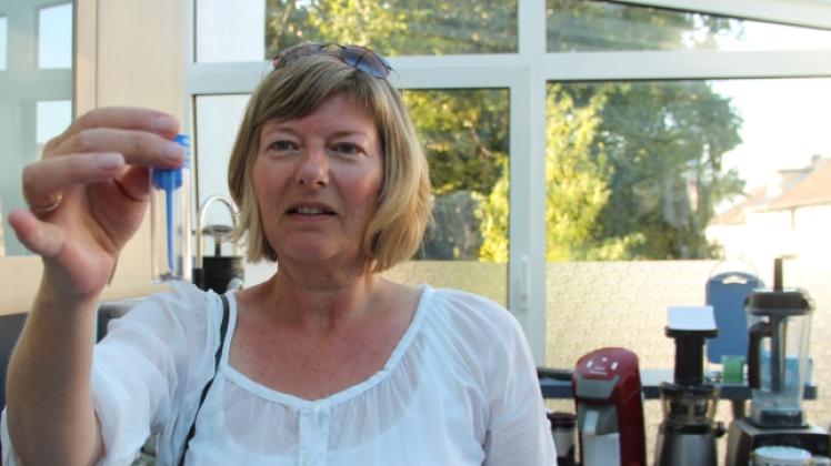 Kerstin Lueckow, Sprecherin der Bürgerinitiative (BI) „Stopp! Kein Mega-Kraftwerk“ begutachtet eine der Proben, die die BI nach einem Partikelausstoß gesammelt hat.  
