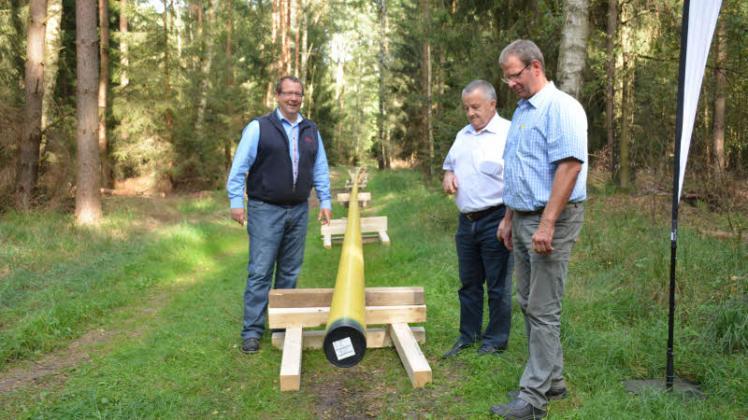 Beim gemeinsamen Baustellengespräch demonstriert Jörg Peters (v.l.) vom HanseWerk Amtsvorsteher Dieter Quast und Bürgermeister Dietrich Groth die Verlegung der neuen Stahlrohre.  