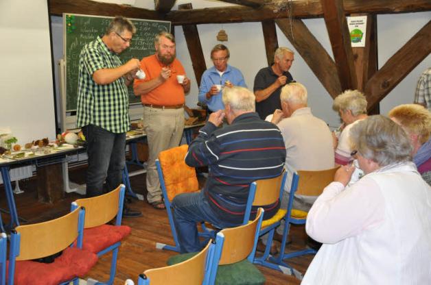 Uwe Jueg (links) und andere Besucher testen die verschiedenen Pilzsuppen. 