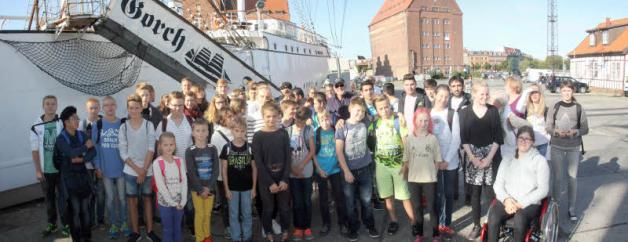 Gruppenbild der jungen Reisegruppe an der Gorch Fock im Hafen von Stralsund