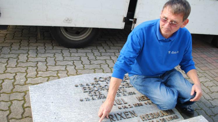 Metalldiebe haben den halben Grabstein geplündert: 47 Buchstaben und Zahlen aus Bronze wurden gestohlen. Frank Schmidt, technischer Betriebsleiter im Steinmetzbetrieb bei der Firma Selck, zeigt die Löcher, in denen die Dübel einst steckten. 