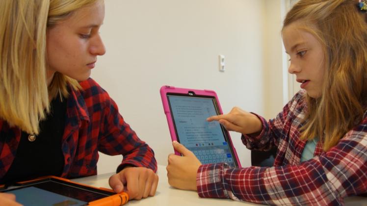 Josie Krey und Antonia Schreiber (rechts) zeigen, welche Möglichkeiten sie mit dem iPad haben. Natürlich schreiben sie aber auch noch ganz „analog“ mit Papier und Stift im Unterricht. 