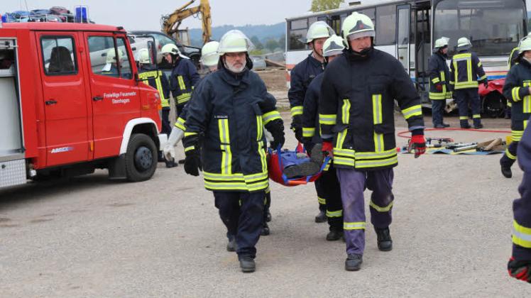 Ottmar Michalski (l.) von der Feuerwehr Neuendorf und weitere Kameraden bergen einen verletzten Businsassen. 
