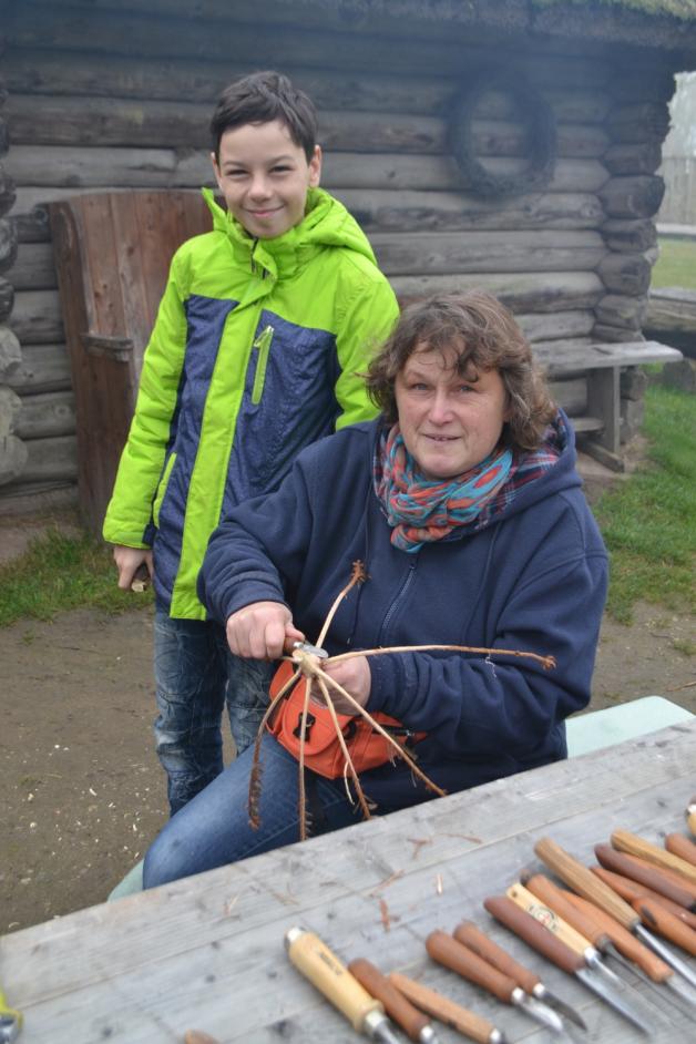 Gabi Konrad fertigt einen Quirl aus Holz, Sohn Felix schaut zu.