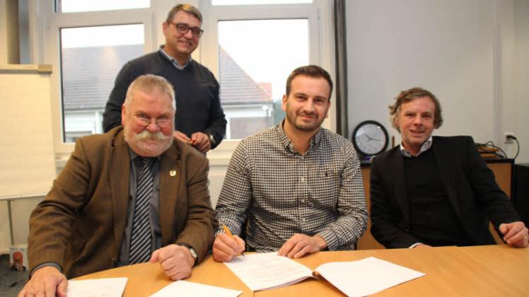 In trockenen Tüchern: Gestern unterzeichneten (v. l.) Gettorfs Bürgermeister Jürgen Baasch und Erdagon Martinovic unter den Augen von Dirk Lettmann und Dirk Schwauna (hinten) den Pachtvertrag.  