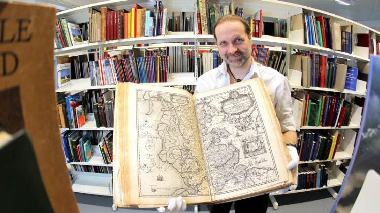 Herr der Bücher: Marco Petersen, wissenschaftlicher Mitarbeiter, mit einem Atlas von Dackwerth-Meyer aus dem Jahr 1652. 