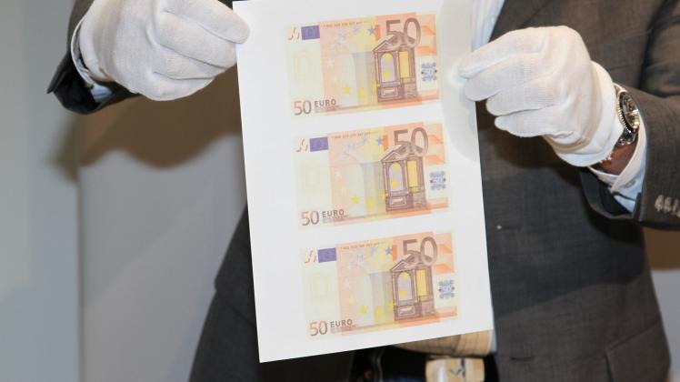 Ermittler präsentieren die gefundenen Druckbögen, aus denen die gefälschten 50-Euro-Scheine gefertigt wurden.