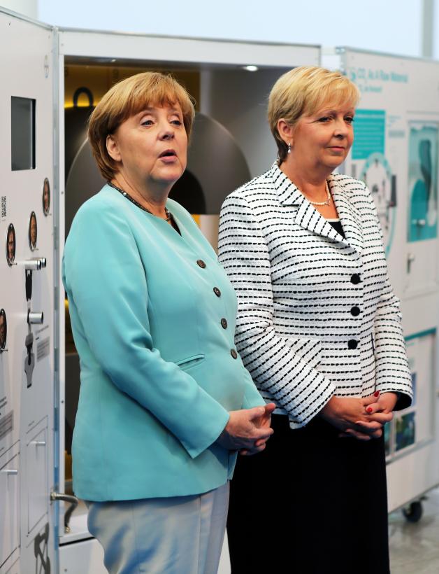 Fast schon türkis ist die Oberbekleidung, die Merkel - hier mit Hannelore Kraft - 2013 bei einem Festakt in Köln trägt.