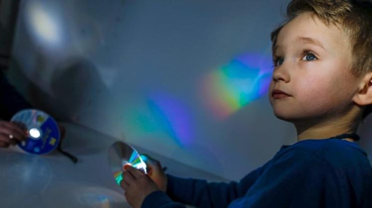 Da leuchten nicht nur die Farben, sondern auch die Augen: „Sandkasteningenieur“ Louis erzeugt mithilfe einer CD und einer Taschenlampe einen Regenbogen. 