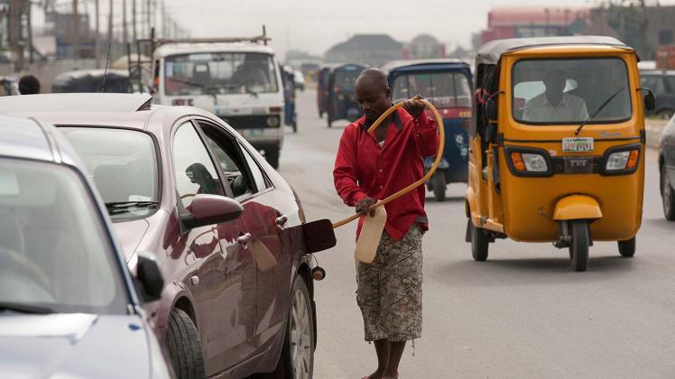 Ein Mann in Nigeria befüllt seinen Wagen mit Benzin vom Schwarzmarkt. Der Treibstoff für Afrika ist oftmals von geringer Qualität und belastet die Umwelt. 