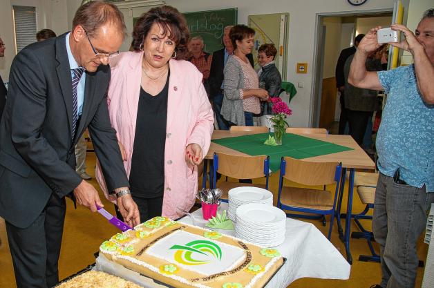 Andreas Cordt schneidet gemeinsam mit Lübtheens Bürgermeisterin Ute Lindenau die große Geburtstagstorte zum 5. Jubiläum der Schule  an.